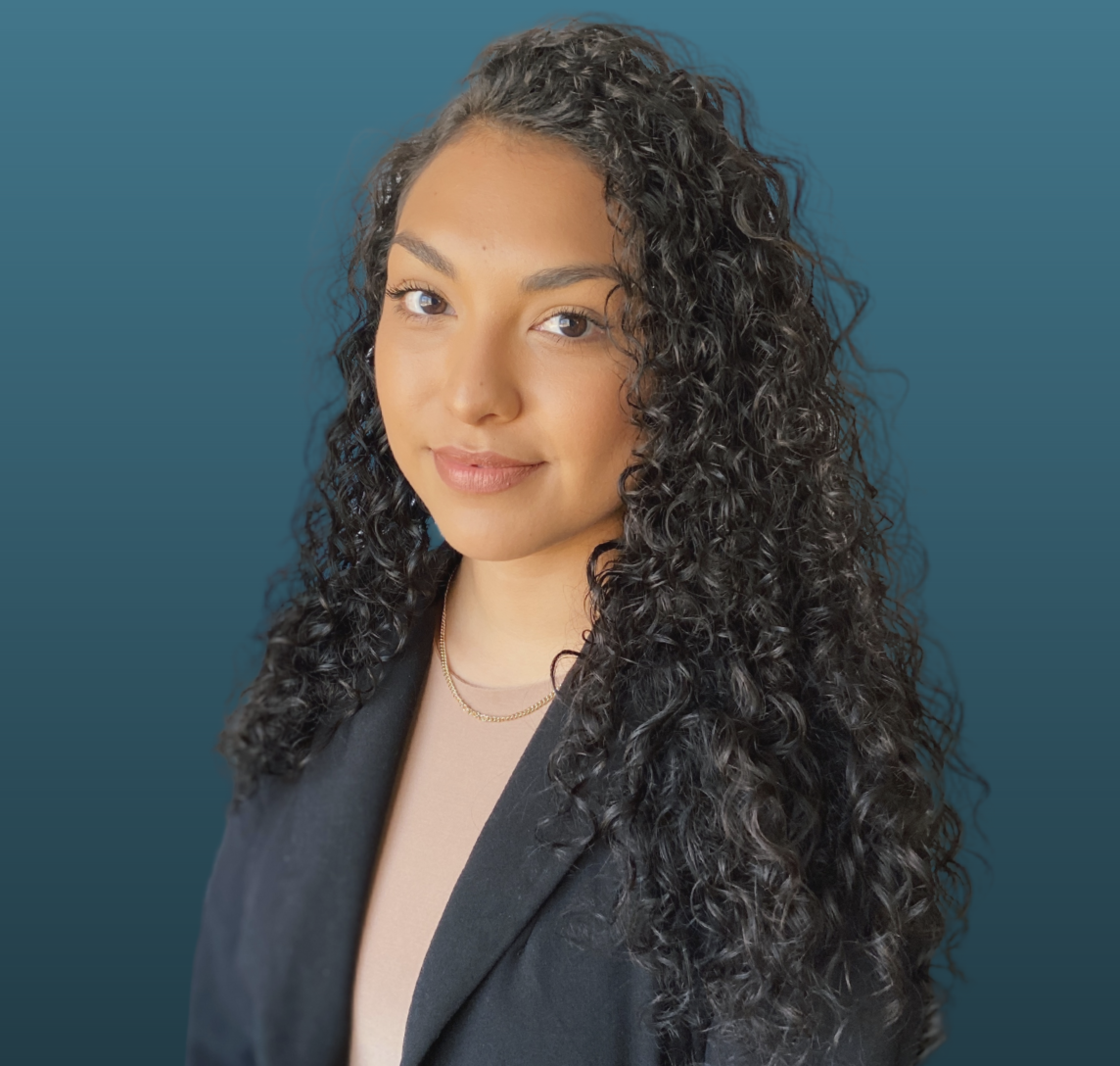 picture of Alondra with long brown curly hair and a blue background.